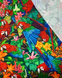 a brightly coloured swatch of fabric with a tropical scarlet macaw motif