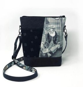 a handmade teloujay crossbody bag featuring a watercolor illustration of an elderly man feeding birds