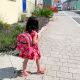 Bright pink mini backpack being worn by a young girl